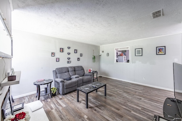 living room with a textured ceiling and wood-type flooring