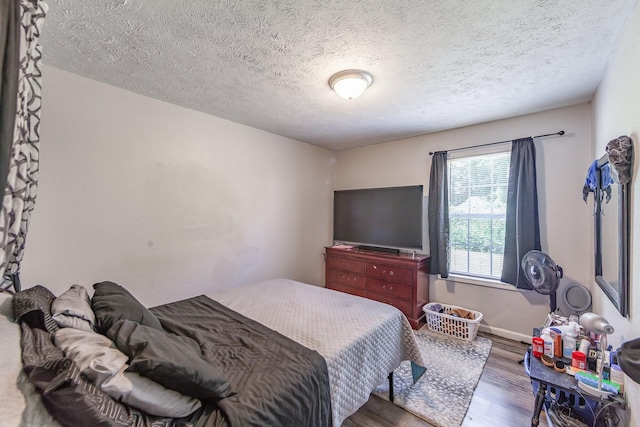 bedroom with a textured ceiling and dark hardwood / wood-style flooring