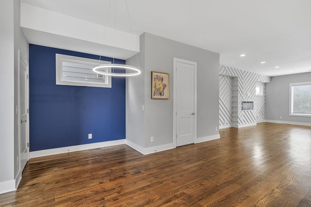 unfurnished living room with dark wood-type flooring and an inviting chandelier