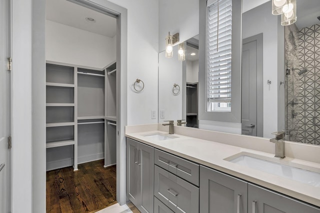 bathroom with wood-type flooring, vanity, and walk in shower