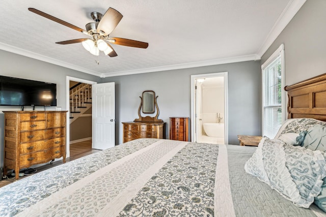 bedroom with ensuite bath, a textured ceiling, ceiling fan, crown molding, and a walk in closet