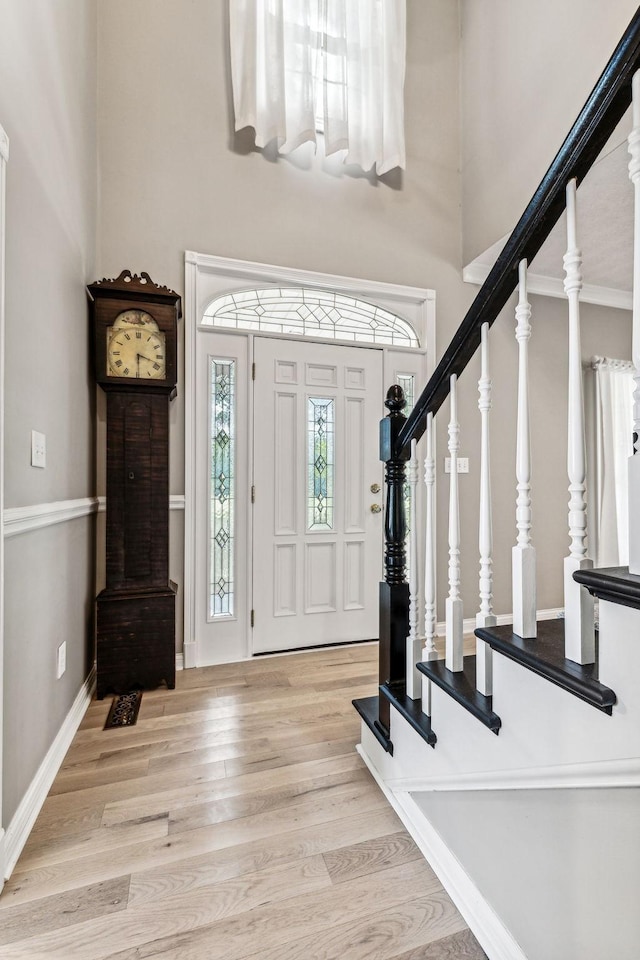 entryway with a high ceiling and light hardwood / wood-style floors