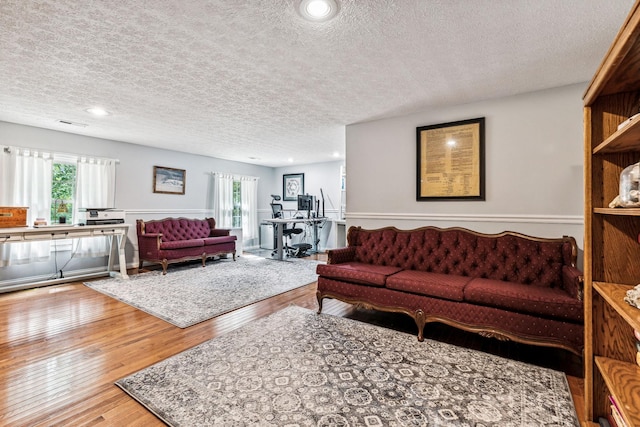 living room featuring wood-type flooring and a textured ceiling