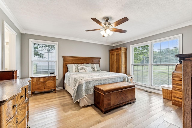 bedroom with ceiling fan, light hardwood / wood-style flooring, crown molding, and a textured ceiling