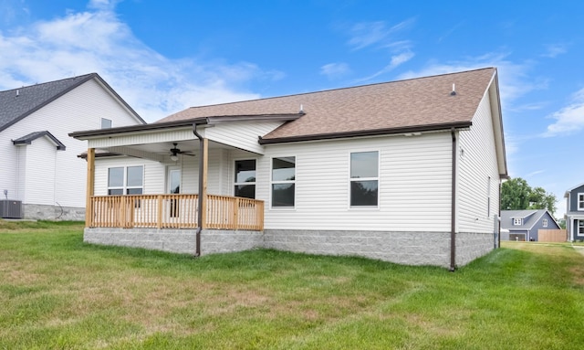 back of property with ceiling fan and a lawn