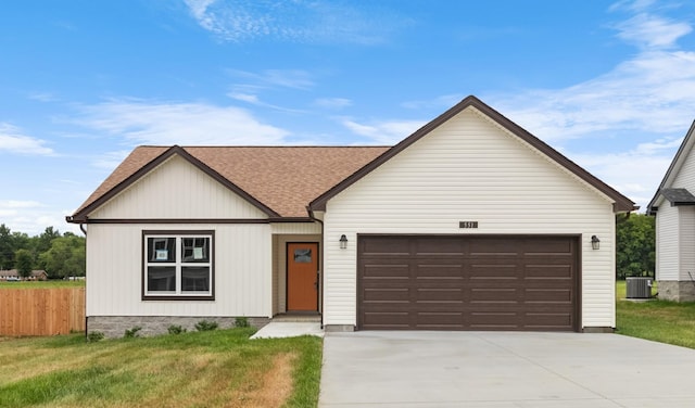 view of front of house with central AC, a front yard, and a garage