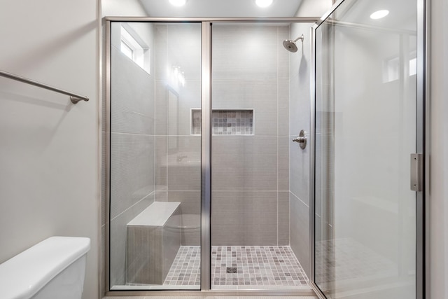 bathroom with toilet and a shower with shower door