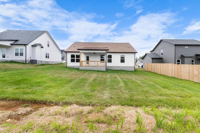 rear view of house with a yard and central AC