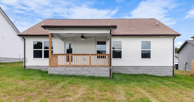 rear view of house featuring ceiling fan and a lawn