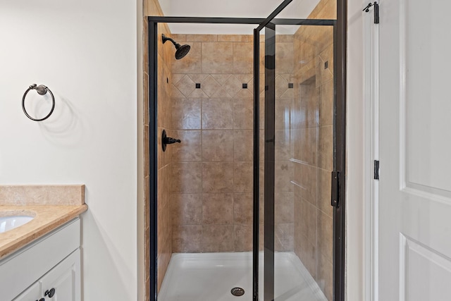 bathroom featuring a shower with door and vanity