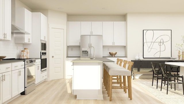 kitchen featuring white cabinetry, a kitchen island with sink, a breakfast bar area, and stainless steel appliances