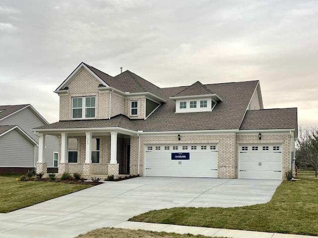 craftsman-style house featuring a garage, a shingled roof, concrete driveway, a front lawn, and brick siding