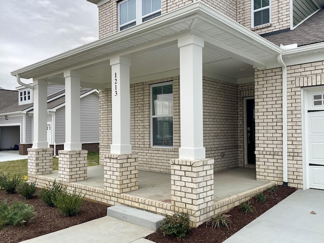 entrance to property with a porch and roof with shingles