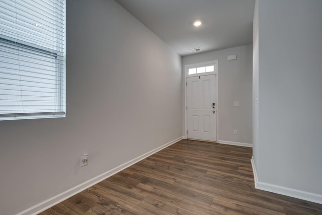 entrance foyer with dark wood finished floors, visible vents, and baseboards