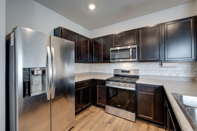 kitchen with stainless steel appliances, light countertops, and backsplash