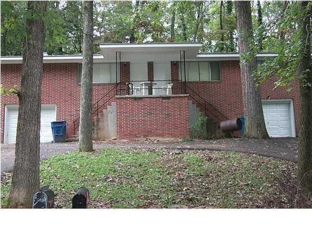 view of front of property with a porch, brick siding, driveway, and stairway