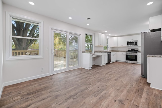 kitchen featuring appliances with stainless steel finishes, sink, white cabinetry, and hardwood / wood-style floors