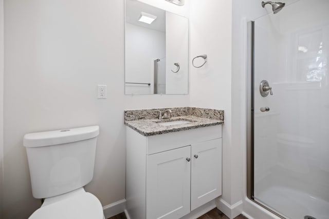 bathroom featuring vanity, toilet, and a shower with door