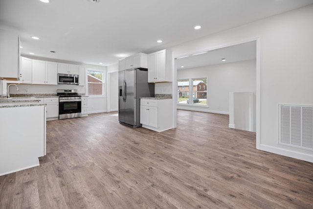 kitchen featuring white cabinetry, sink, stainless steel appliances, and light hardwood / wood-style flooring