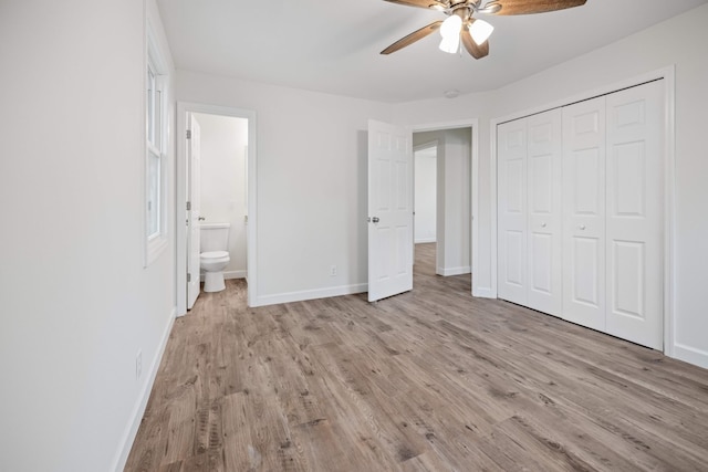 unfurnished bedroom featuring ceiling fan, a closet, ensuite bathroom, and light hardwood / wood-style floors