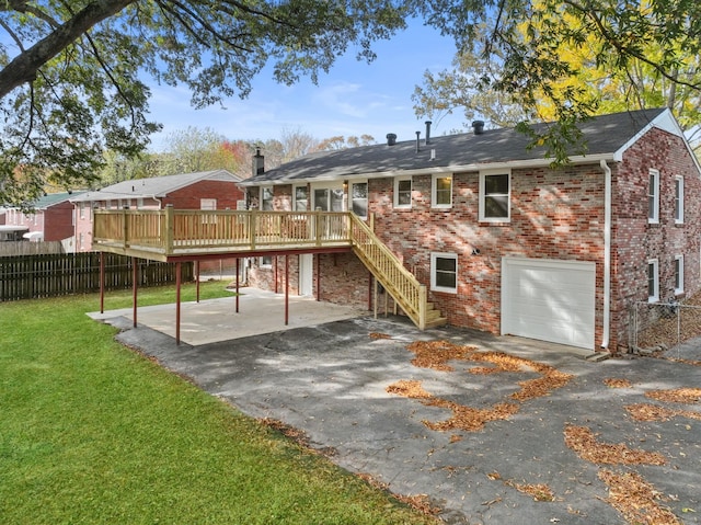 back of property featuring a garage, a lawn, a wooden deck, and a patio area