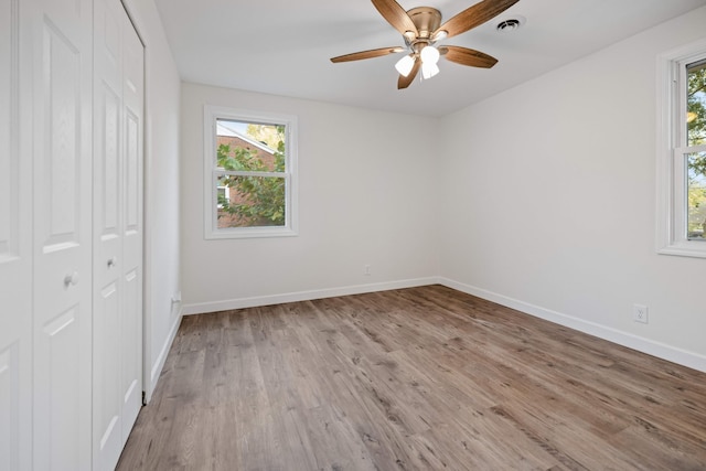 unfurnished bedroom featuring ceiling fan, light hardwood / wood-style floors, and a closet