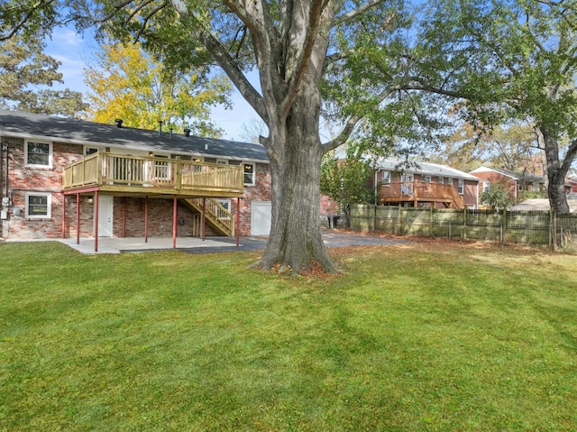 rear view of house featuring a yard, a deck, and a patio