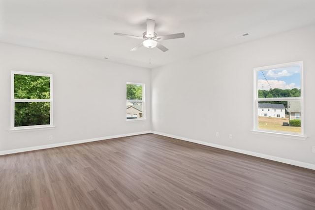 empty room featuring hardwood / wood-style flooring, ceiling fan, and a wealth of natural light