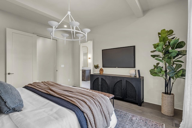 bedroom featuring hardwood / wood-style flooring, beamed ceiling, ensuite bath, and a notable chandelier