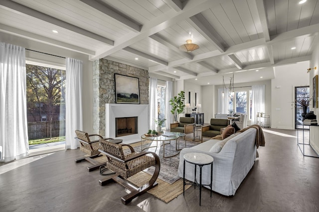 living room with a fireplace, beamed ceiling, and dark hardwood / wood-style flooring