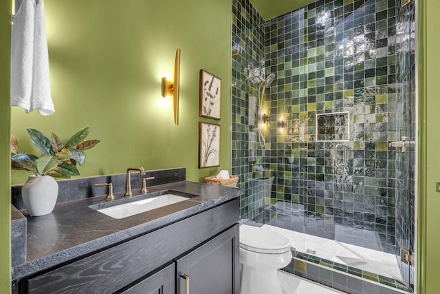 bathroom with toilet, vanity, and a shower with shower door