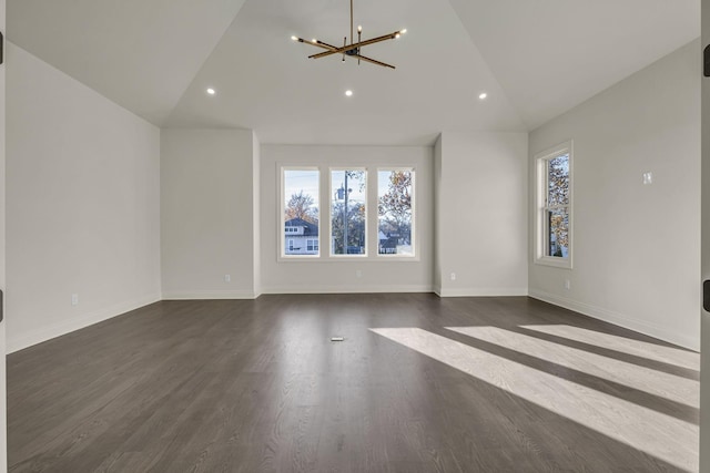 unfurnished living room featuring a chandelier, dark wood-type flooring, and lofted ceiling