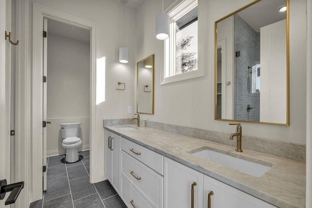 bathroom with toilet, vanity, and a tile shower