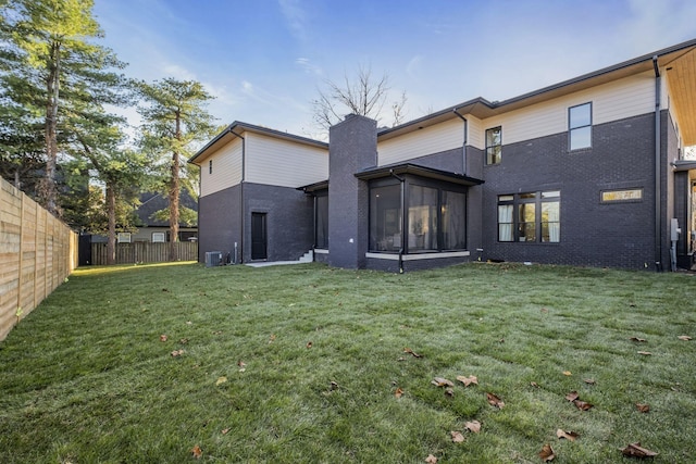 rear view of property featuring a lawn