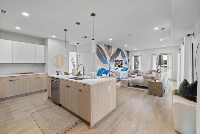 kitchen featuring white cabinetry, a center island with sink, sink, stainless steel dishwasher, and light brown cabinets