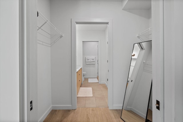 walk in closet with light hardwood / wood-style floors