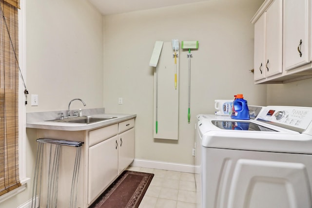 clothes washing area with sink, cabinets, and separate washer and dryer