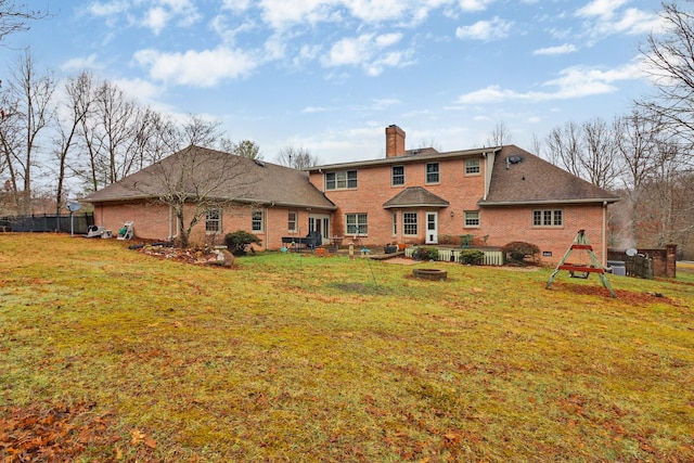 rear view of property featuring a lawn