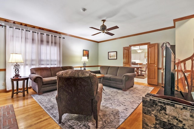 living room featuring ceiling fan, ornamental molding, and light hardwood / wood-style floors