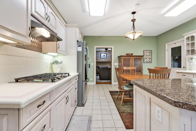 kitchen featuring light tile patterned floors, white cabinetry, decorative light fixtures, stainless steel appliances, and decorative backsplash