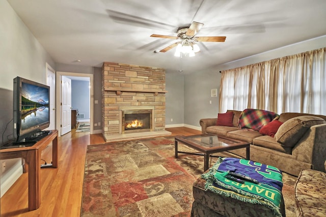 living room with a fireplace, ceiling fan, and hardwood / wood-style floors