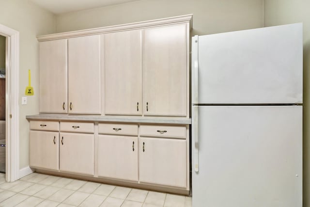 kitchen with white fridge and light tile patterned floors