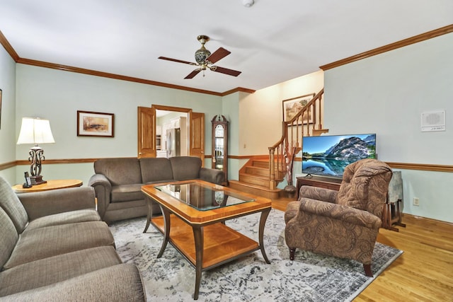 living room with light wood-type flooring, crown molding, and ceiling fan