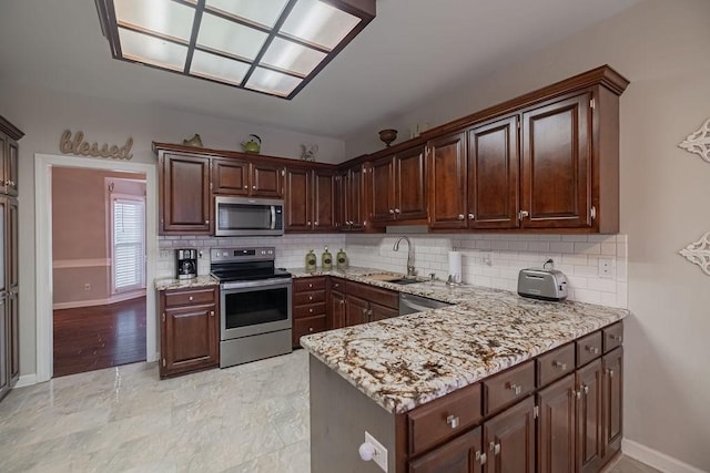 306 Amherst Dr, Tullahoma, TN 37388 - kitchen featuring stainless steel appliances, a sink, decorative backsplash, and light stone countertops
