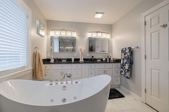 306 Amherst Dr, Tullahoma, TN 37388 - bathroom with a freestanding bath, double vanity, marble look tiles, and baseboards