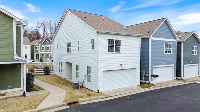 view of side of property with a garage and central air condition unit