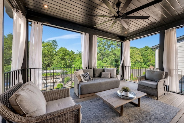 sunroom featuring a healthy amount of sunlight, ceiling fan, and wood ceiling