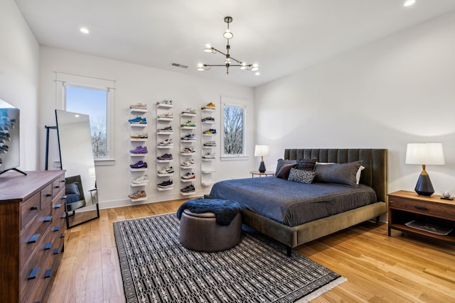 bedroom featuring light hardwood / wood-style floors and a chandelier