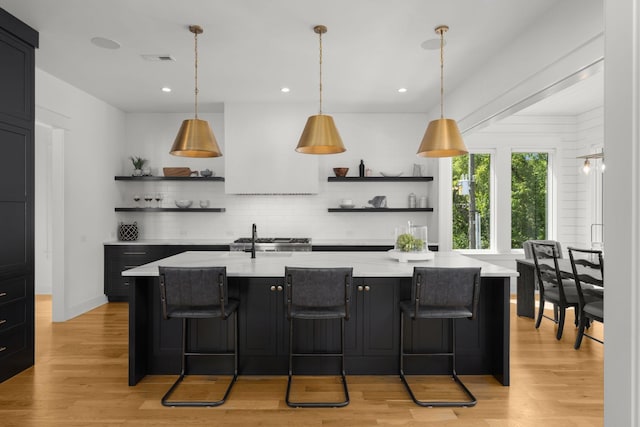 bar featuring light hardwood / wood-style flooring, backsplash, light stone counters, stove, and hanging light fixtures