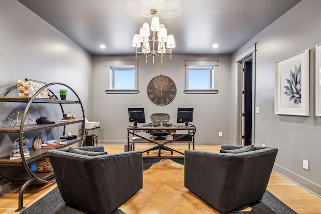 living room featuring a wealth of natural light, an inviting chandelier, and light hardwood / wood-style floors